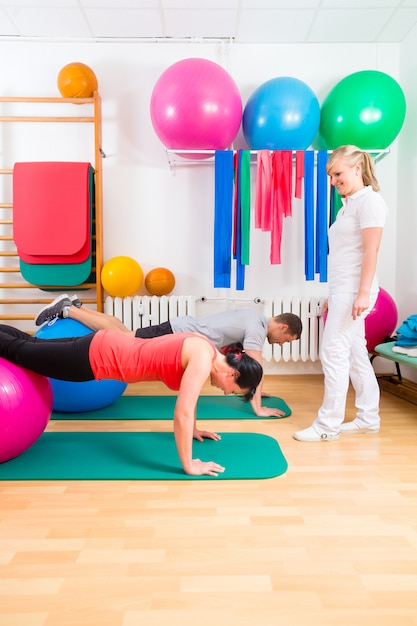 Physiotherapist giving patients gymnastic exercise