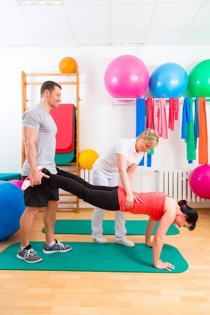 Physiotherapist giving patients gymnastic exercise