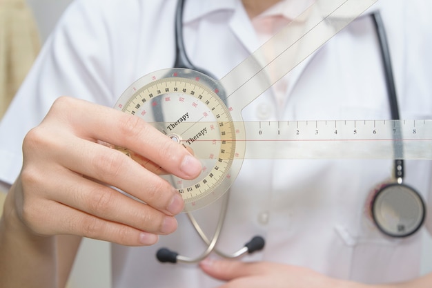 physiotherapist  holding  a goniometer for measuring range of motion