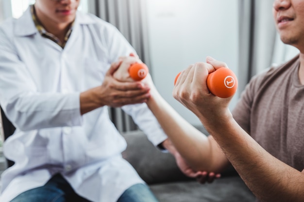 Physiotherapist and man doing exercise with dumbbell