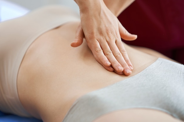 physiotherapist in mask helping female patient