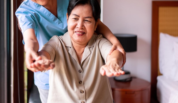 Physiotherapist training with elderly asian women patient at home Physical therapy concept