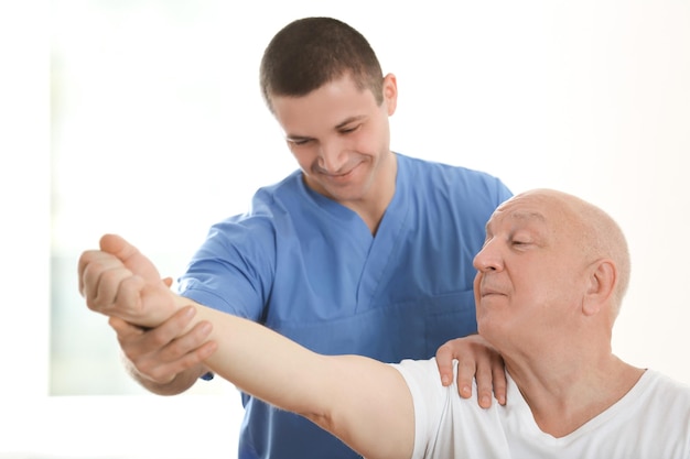 Physiotherapist working with elderly patient in clinic