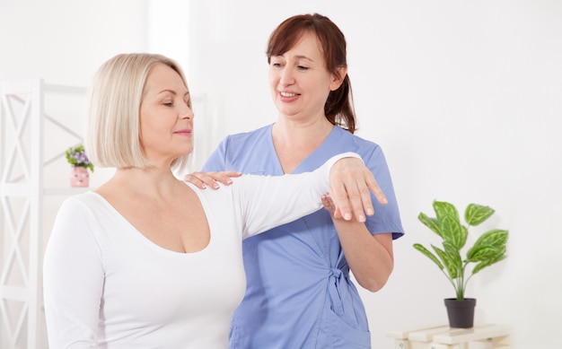 Physiotherapist working with middle aged patient in clinic