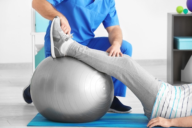 Physiotherapist working with senior patient in modern clinic