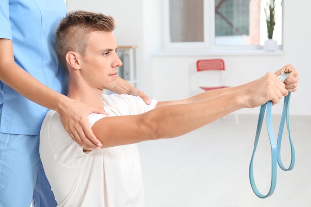 Physiotherapist working with young male patient in clinic