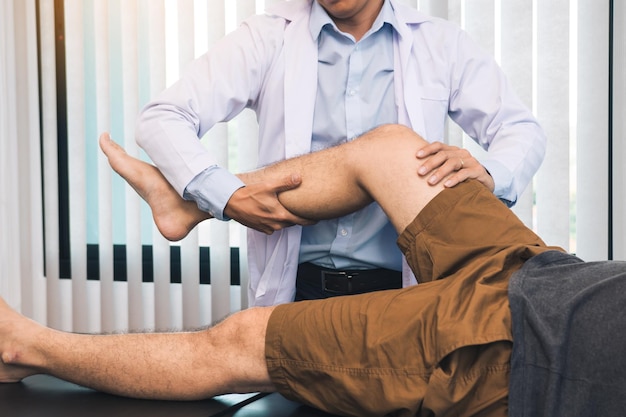 Physiotherapists are using the hands to grip the patient thigh to check for pain and massage in the clinic