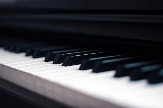 Piano and Electronic piano keyboard with black backgrounds. Closeup of black and white piano keys,  copy space, banner