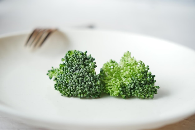 Picking raw broccoli with fork