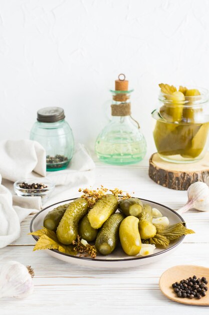 Pickled cucumbers on a plate and ingredients for cooking on a wooden table Homemade appetizers Vertical view