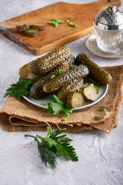 Pickled cucumbers with herbs and onions in a plate on the table Probiotics food