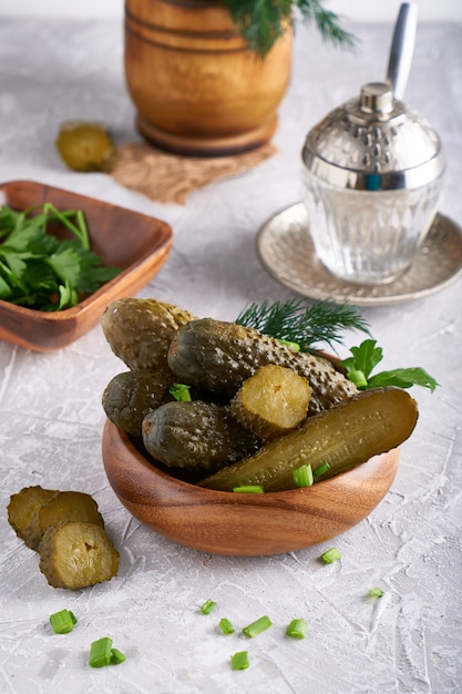 Pickled cucumbers with herbs and onions in a plate on the table Probiotics food