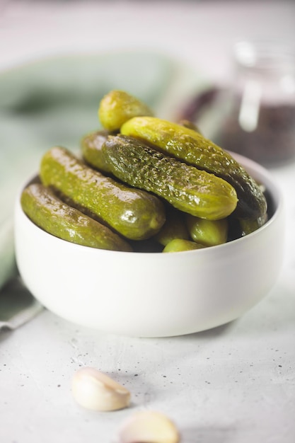 Pickled gherkins. Salted Cucumbers on a gray concrete background