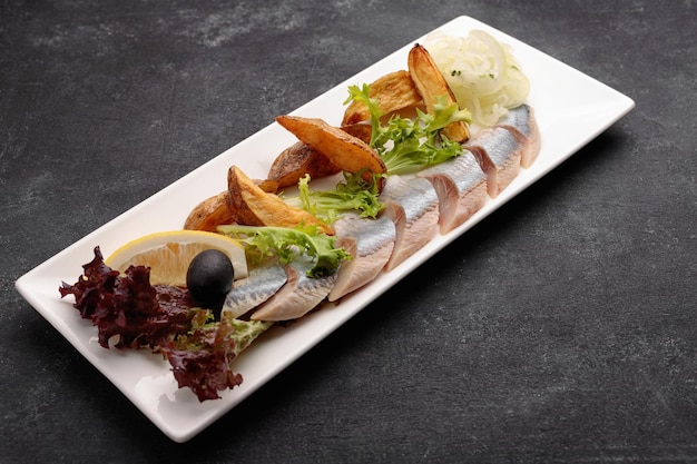 Pickled Herring with baked potatoes onions and lettuce