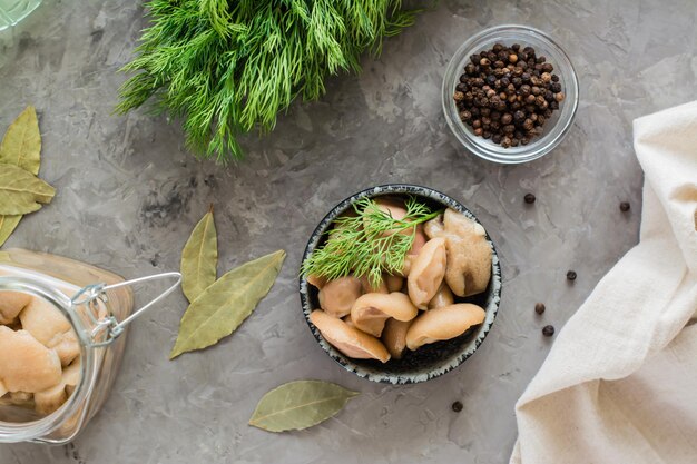 Pickled mushrooms - boletus in a bowl and in a glass jar on the table. Organic vegetarian food. Top view