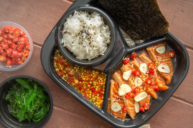 Pickled salmon with shoyu or soy sauce and spicy dipping sauce Thai style food.