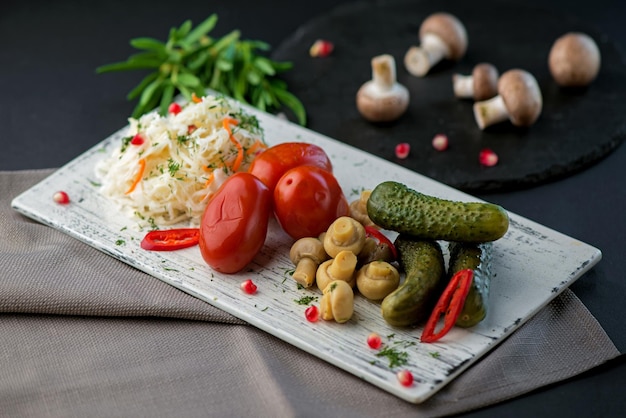 Pickled vegetables mix in the bowl on a dark wooden background