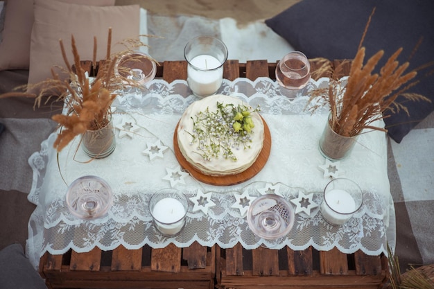 Picnic in the evening at sunset on the sandy shore of the sea or ocean decor in boho and rustic style