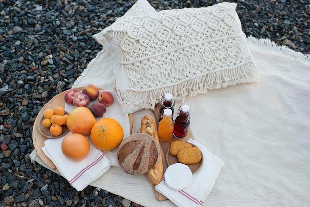 Picnic on the lake shore, a blanket with a basket, fruit and juice