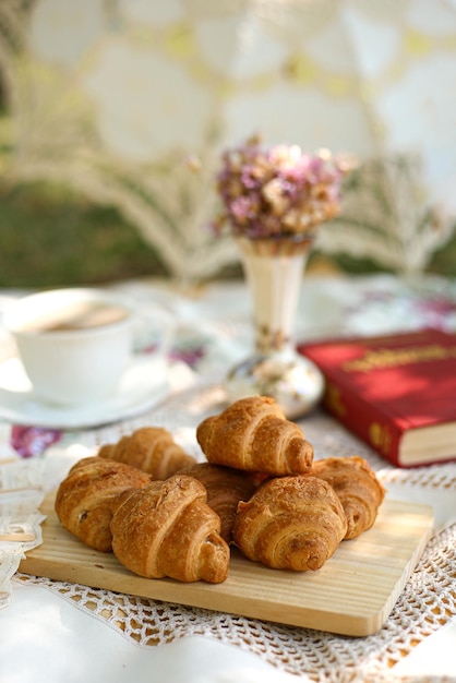 Picnic in nature in summer with croissants book and flowers