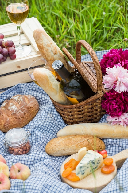 Picnic at the park on the grass: wine, cheese and bread