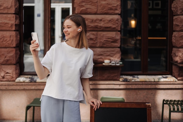 Picture of attractive woman smiling at smartphone in the street