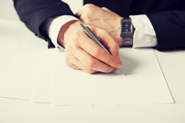 Photo picture of businessman writing something on the paper