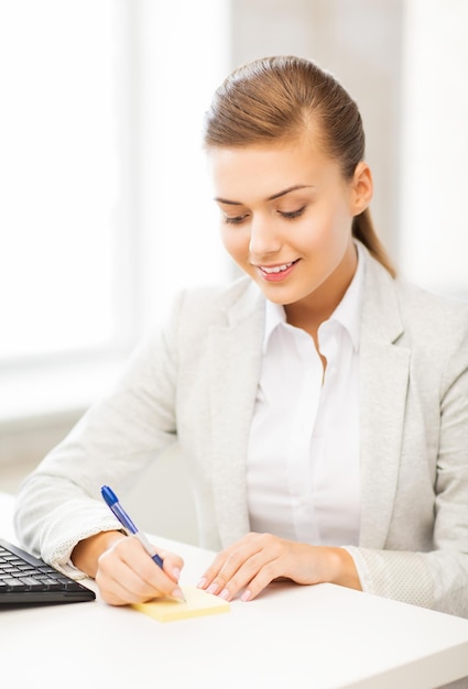 picture of businesswoman writing on sticky note