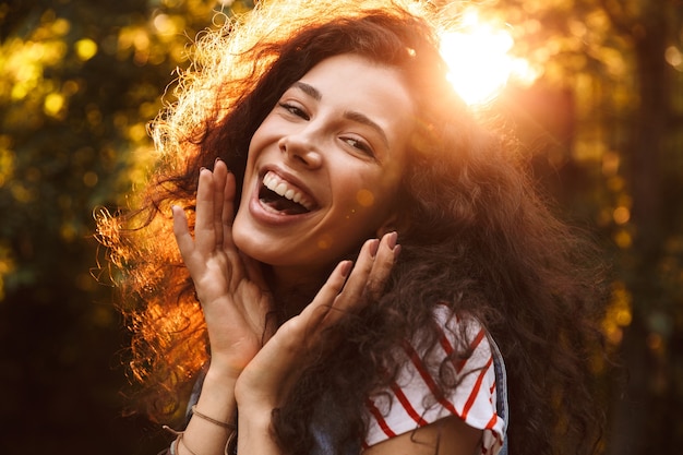 Picture closeup of amazed cute woman laughing at you, while walking through park in sunny day