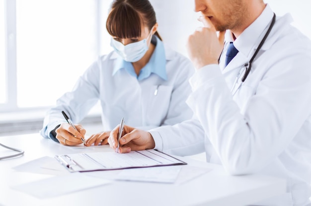 picture of doctor and nurse writing prescription paper