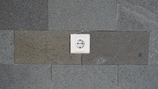 Picture of an electrical plugs with a greycoloured wall background