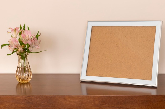 Picture frame on table with flower vase