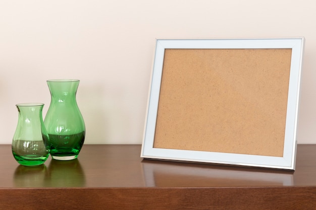 Picture frames and green vases on the table