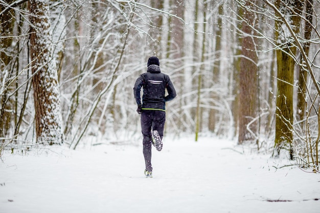 Picture from back of man in sports clothes on run in winter