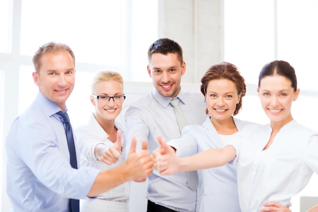 picture of happy business team showing thumbs up in office