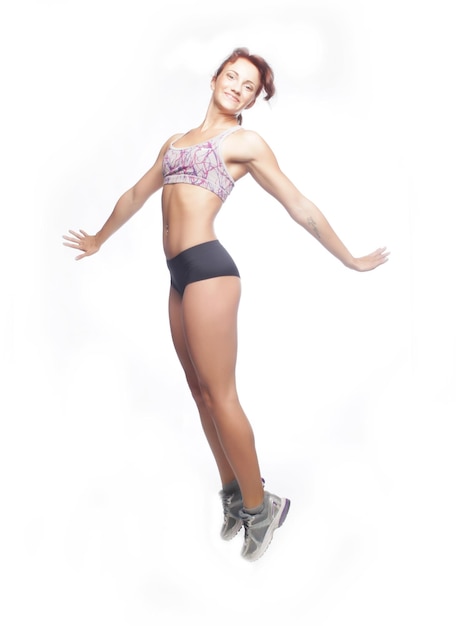 Picture of happy jumping sporty girl over white background