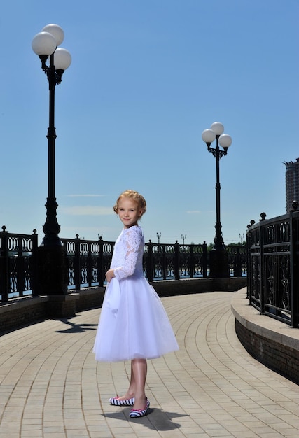 Picture of a little girl in white dress posing outdoor