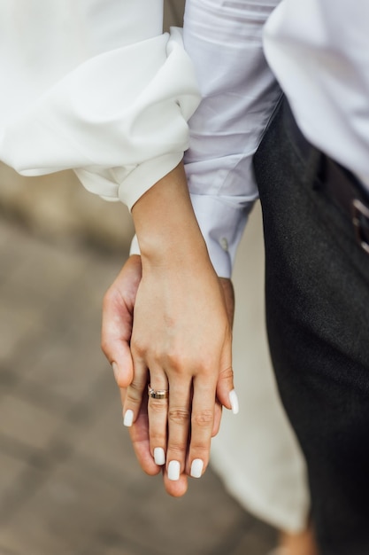 Picture of man and woman with wedding ringYoung married couple holding hands ceremony wedding day Newly wed couple's hands with wedding rings