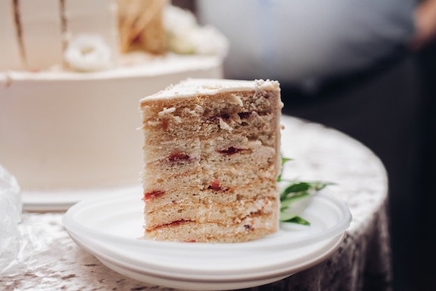 Photo picture of a piece of a yummy white wedding cake on a plate