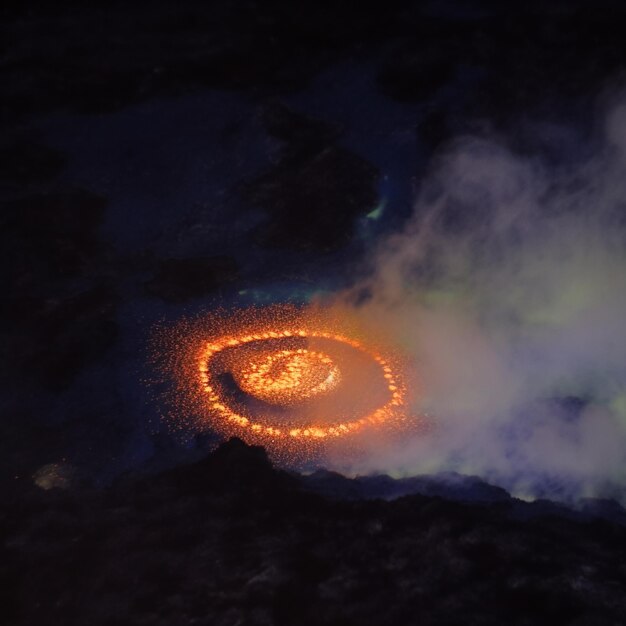 Photo a picture of a rock with a circle of fire and a green light in the background