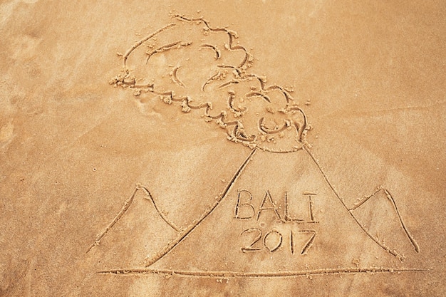 Picture on sand Drawn volcano with text Bali inside