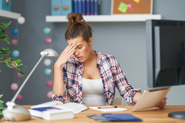 Picture showing tired female student learning late at home