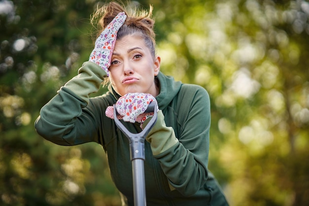 Picture of tired woman working with tools in the garden