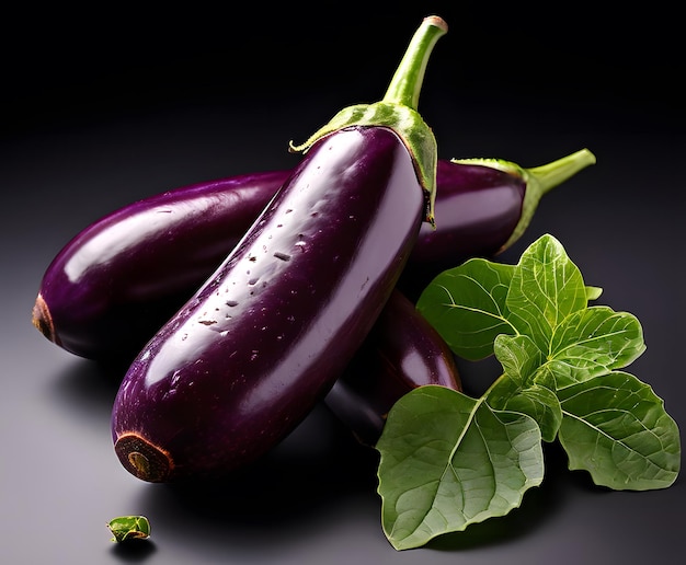 Picture of two aubergine with leaf on dark background