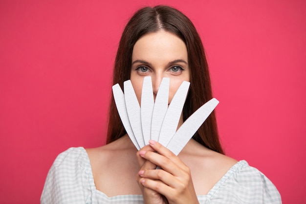 picture of young girl holding nail files near face