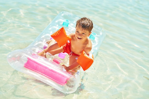 Picture of young happy boy swimming on mattress on Red Sea