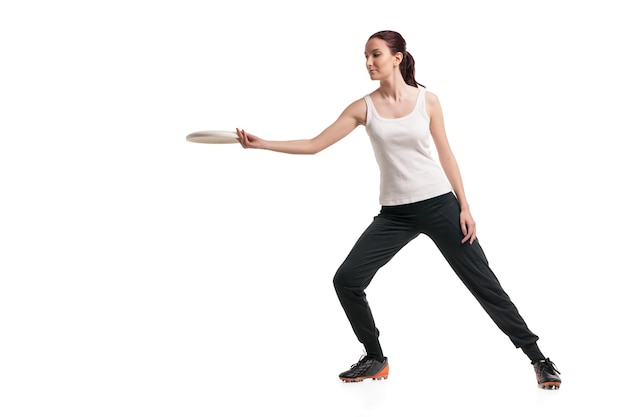 Picture of young happy woman playing with flying disc over white background