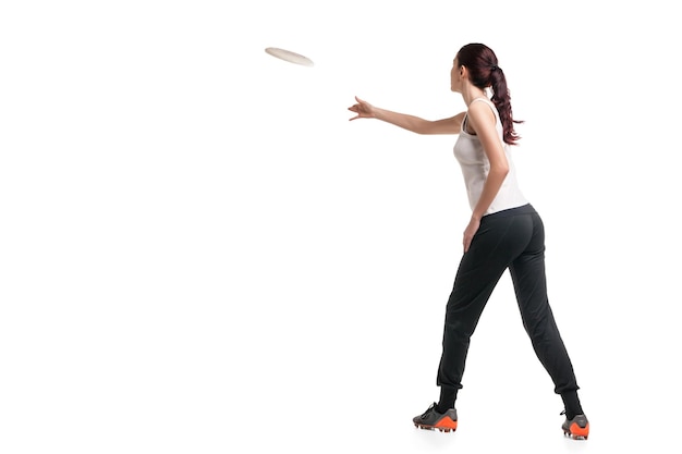 Picture of young happy woman playing with flying disc over white background