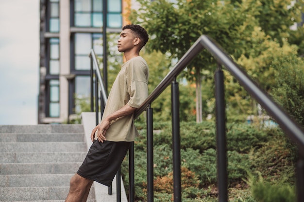 Picture of a young man in a thsirt standing outside