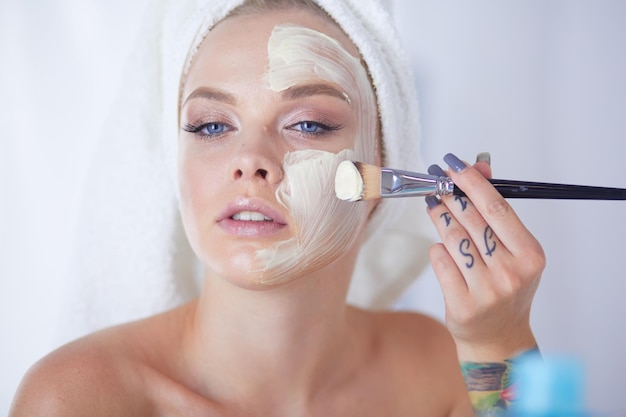 A picture of a young woman applying face powder in the bathroom